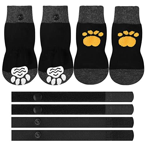 Four black dog booties with paw print design and adjustable straps.